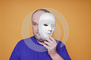 Man taking off mask revealing face and identity photo