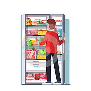 Man taking out juice from the open refrigerator
