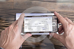 Man Taking Photo Of Cheque To Make Remote Deposit