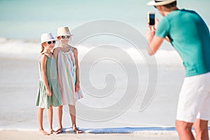 Man taking a photo of his kids on the beach