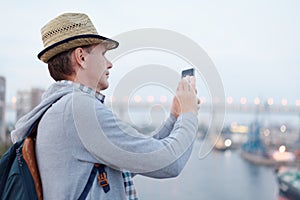 Man taking photo with mobile phone on the deck of cruise ship