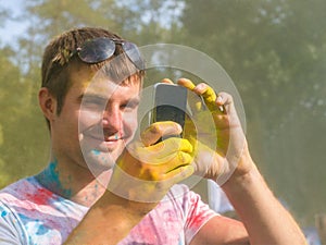 Man taking photo on mobile phone on holi color festival