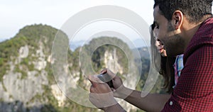 Man Taking Photo Of Mountain Landscape On Cell Smart Phone Showing To Tourists Group Talking
