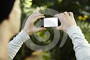 Man taking photo picture by mobile phone in a travel journey. Blank screen for design layout Focused on phone screen