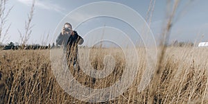 Man taking photo on yellow field.