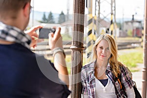 Man taking photograph of woman digital camera