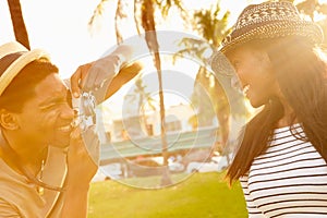 Man Taking Photograph Of Woman In Park