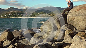 Man taking a photos with dslr camera outdoors, on the beach