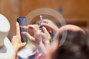 Man taking photos of the procession using mobile phone.