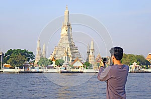 Man Taking Photos of the Temple of Dawn or Wat Arun, Bangkok, Thailand