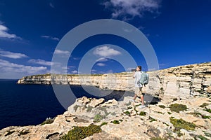 Man taking picture of coastline near Azure Window on Gozo Island