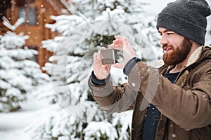 Man taking pictures with mobile phone in winter