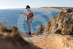 Man taking pictures of ocean landscapes, Ponta da Piedade near Lagos, Portugal