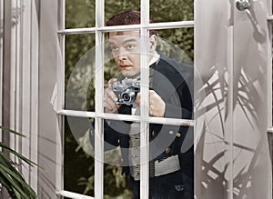 Man taking pictures through window