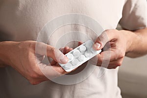 Man taking pill out from blister pack, closeup