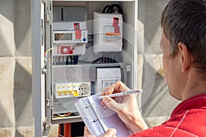 Man taking readings of an electric meter