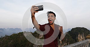 Man Taking Selfie On Mountain Top On Cell Smart Phone, Hispanic Guy Happy Smiling To Camera