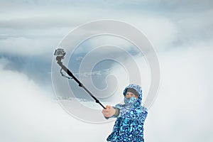 Man taking selfie at the mountain using action camera