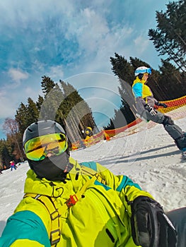 man taking selfie in ski mask and goggles at snowed hill