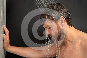 Man taking shower. Man washing hair with shampoo under water falling from shower head. Morning routine guy showering