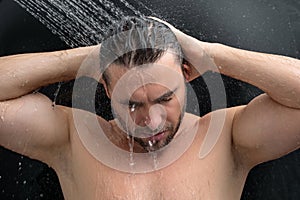 Man taking a shower. Washing hair with shampoo under water falling from shower head. Morning routine lifestyle guy