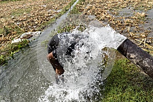 Man taking a shower washing hair under water falling from motor water drops. Cleaning with high pressure motor water in summer hot