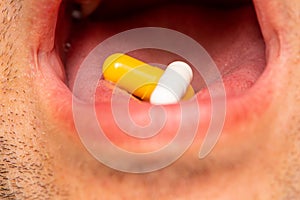 Man taking two pills as a medicine