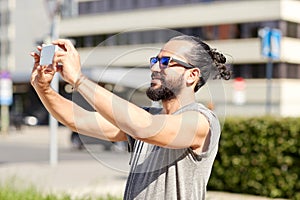 Man taking video or selfie by smartphone in city