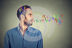 Man talking with alphabet letters in his head and coming out of open mouth photo
