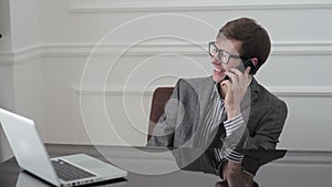 A man talking on a cell phone and laughing.