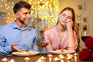 Man talking with hands, uninterested woman at dinner