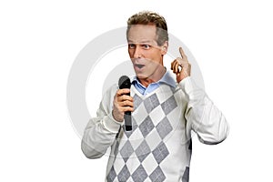 Man talking into microphone on white background.