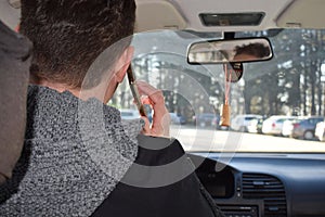 A man is talking on the phone while driving a car