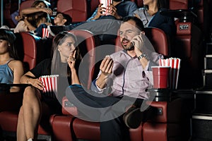 Man talking on the phone at the movies