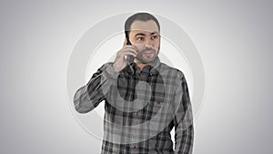 A man is talking on the phone and smiling on gradient background.