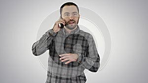 A man is talking on the phone and smiling on gradient background.