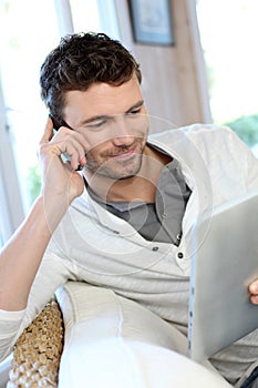 Man talking on the phone and using tablet