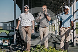 man talking on smartphone while friends walking