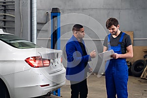 Repairman talking to a man about a car repair