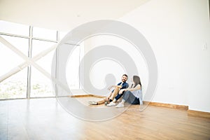 Man Talking With Woman In Empty Room Of New House