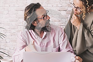 Man talking with woman at office in front of a computer. Concept of team worker couple working together on online small business.