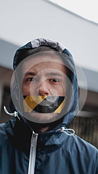 Man with tape over his mouth photo