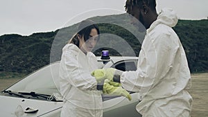 Man taping bacteriological protective gloves to a woman