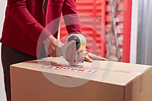 Man Taping Moving Boxes in Warehouse