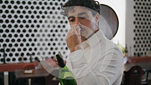 Man tasting smell cork wine bottle standing winery cellar alone close up.