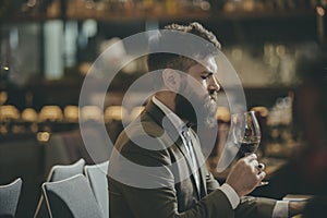 Man tasting wine in restaurant or bar interior