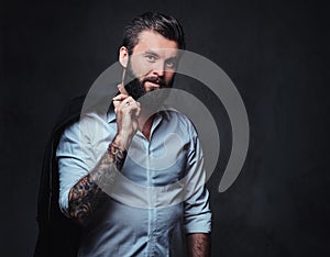 A man with tattoo on arm dressed in a shirt.