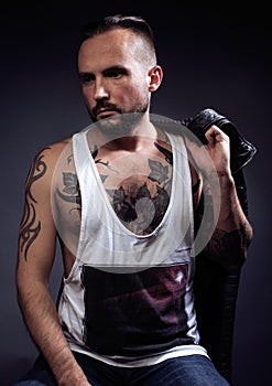 A man with tattooes on his arms. Silhouette of muscular body. caucasian brutal hipster guy with modern haircut, looking