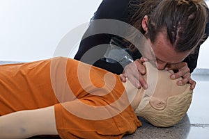 Man teaching cardiopulmonary resuscitation with a dummy on a white background. Doing Mouth-to-mouth to breathe air