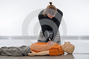 Man teaching cardiopulmonary resuscitation with a dummy on a white background. Performing chest compressions for cardiac massage